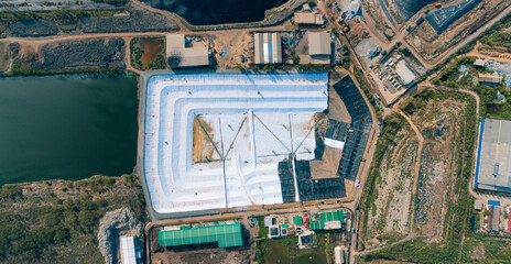 Aerial Top View Waste water treatment ponds from giant trash mountain. Giant garbage mountain in trash dump or open landfill, Trash trucks dump waste products polluting in an trash dump