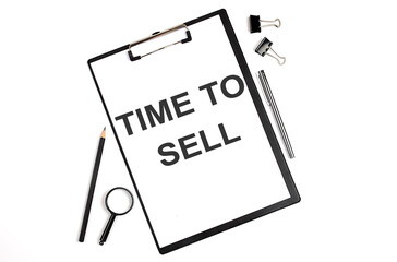 On a white background magnifier, a pen and a sheet of paper with the text TIME TO SELL , . Business concept