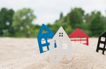 Fototapeta na wymiar Models of houses stand in the sand