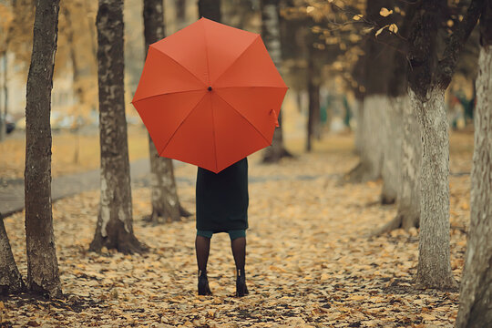 girl with umbrella posing in autumn park, october landscape lonely woman holding a red umbrella