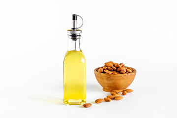 Almond nut oil in glass bottle with almond nuts. Extra virgin essence oil