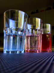 Three colored glasses of mineral water on the table from an unusual angle
