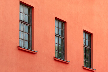 Fototapeta na wymiar A row of old windows on the red wall