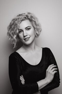 Headshot of gorgeous attractive young lady with curly hair smiling. Black and white picture. Marilyn Monroe.