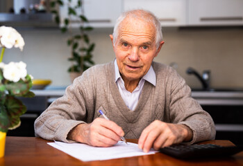 elderly senior writing letter on paper at home