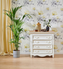 Decorative flower wallpaper background, wooden chair and cabinet style with green vase of plant, yellow carpet and home accessory style.