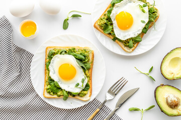 Breakfast with toasts of fried eggs and avocado saurce. Top view