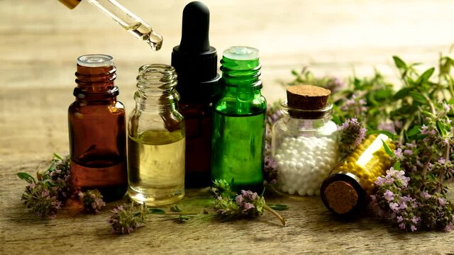 Thyme essential oil in a small bottle. Selective focus.