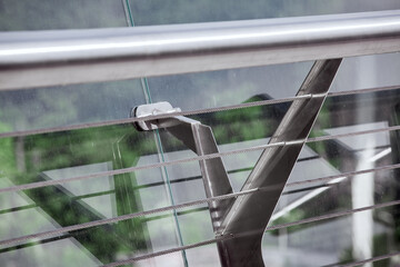 railings with glass panels fastenings enclosing the edge of the pedestrian bridge with tension...
