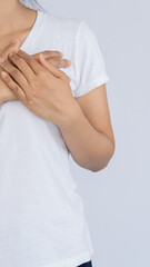 Young woman with chest pain in a white shirt white background