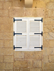 Window closed shutters on the wall of a house