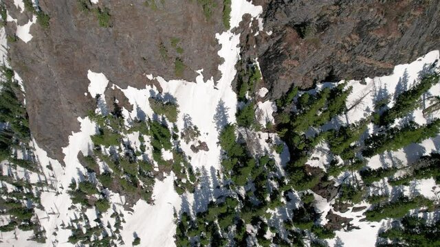Mountain Summit Aerial Reveal from Snowy Forest Canopy to Rocky Peak