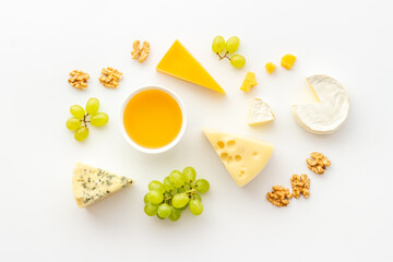 Various types of cheese with honey and grapes. Flat lay top view
