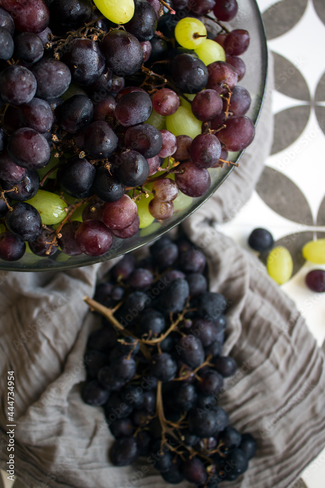 Wall mural Grapes in a vase. Close up photo of fresh seasonal fruits. Eating fresh concept. Beautiful grapes on a table. Summer berries texture. 