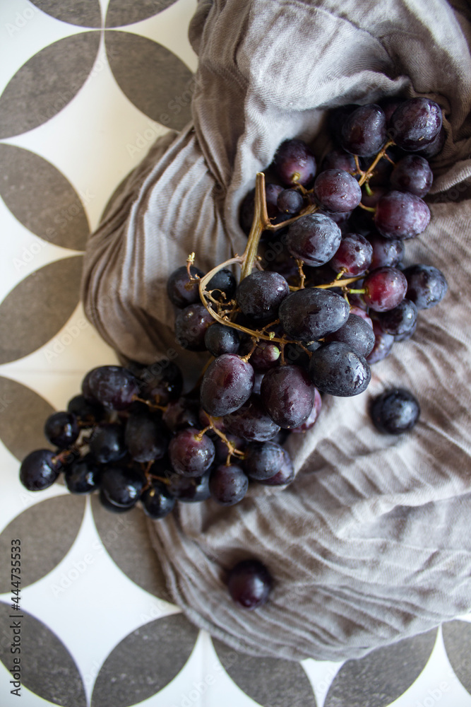 Wall mural Grapes close up photo. Beautiful black berries on a table. Healthy eating concept. Summer fruits top view. 