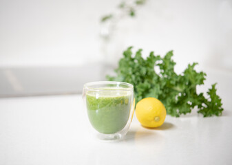 Kale and lemon smoothie in a glass isolated on mable countertop