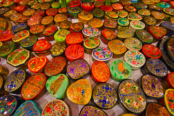 Traditional Kashmir wooden decorated small jewelry boxes. The shapes, colors and patterns are very diverse. View of Dal Lake in Srinagar, Kashmir State, India. June 2018