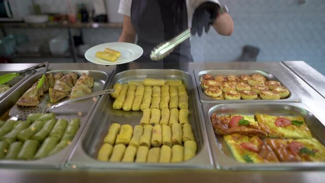 in a school cafeteria or a buffet on the food service line, the attendants put the food on a plate of pancakes with cottage cheese. Delicious dessert.