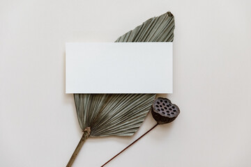 Minimal Summer stationery still life scene. Mock up with blank card and tropical palm leaf on beige neutral background. Blank greeting card, wedding invitation mockup scene - 444739993