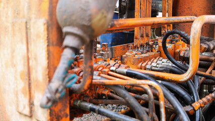 Old hydraulic valves and hoses. The pipeline system of the hydraulic valve of the mobile crane....