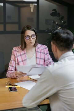 interview or negotiation, a successful and beautiful business woman in her office interviewing a man or discussing a work plan with a colleague or subordinate, hr specialist or psychologist