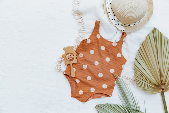 Baby summer background, Flat lay retro child swimsuit with palm leaf and accessories. Summer kids holiday concept, top view, flat lay