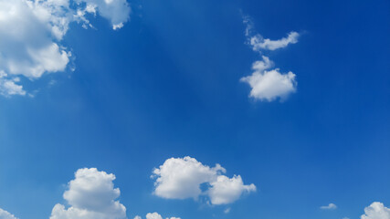 White cumulus clouds in the sky on a sunny summer day.