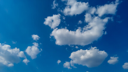 White cumulus clouds in the sky on a sunny summer day.