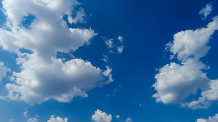 White cumulus clouds in the sky on a sunny summer day.