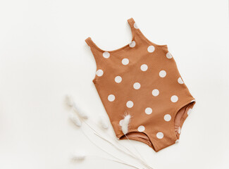 Summer kid's vacation concept - flat lay retro swimsuit on neutral background. Holiday concept, fashion child