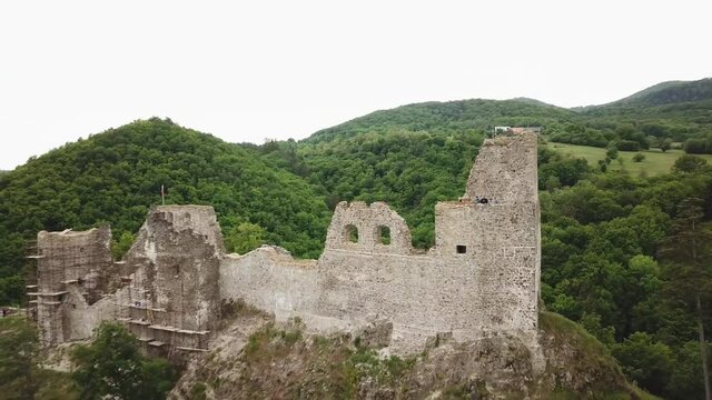 Reviste castle. The ruins of a Gothic castle located above the town of Žarnovica and Vtacnik mountain. Aerial footage.