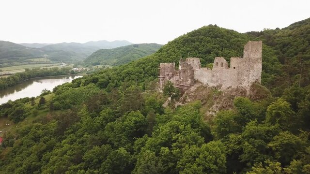 Reviste castle. The ruins of a Gothic castle located above the town of Žarnovica and Vtacnik mountain. Aerial footage.