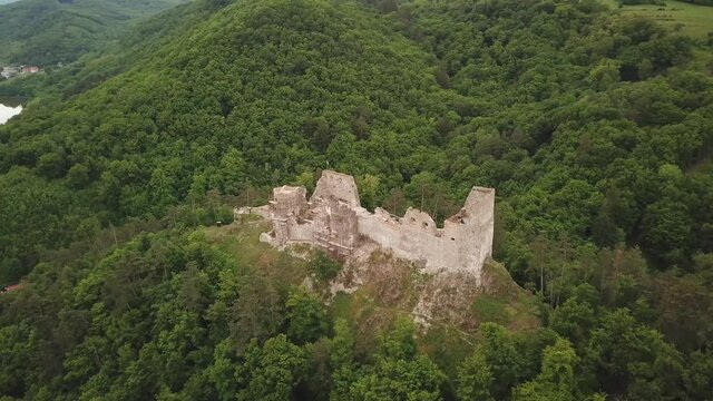 Reviste castle. The ruins of a Gothic castle located above the town of Žarnovica and Vtacnik mountain. Aerial footage.