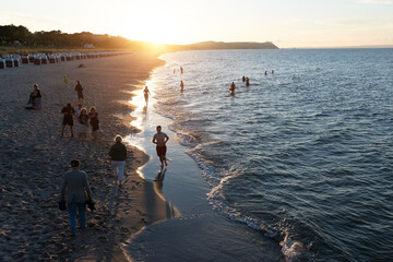 Menschen am Meer bei Sonnenuntergang