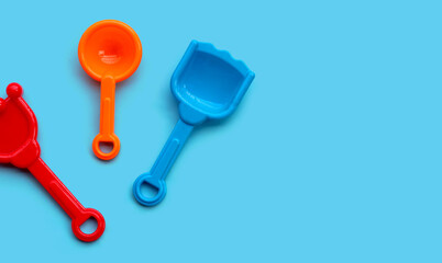 Plastic toys, shovels on blue surface.
