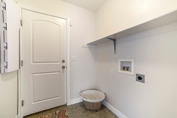 Interior of a laundry room with shelf and woven basket