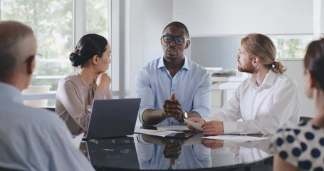 African businessman explaining strategy to diverse colleagues at corporate meeting