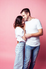 young cheerful caucasian couple together having fun on pink background, guy ang girl modern relationship, lifestyle people concept