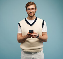 Happy man in glasses typing sms on blue background.