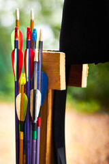 Close up of plastic arrows in a quiver with targets in the background