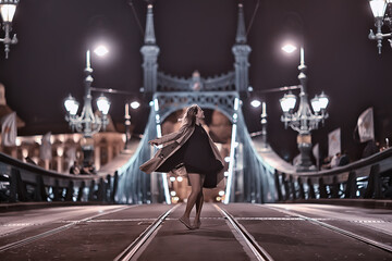Obraz premium girl in a coat, spring glance, night walk in budapest chain bridge landscape