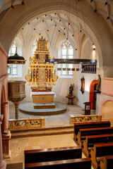 Krasne Brezno, Bohemia, Czech Republic, 26 June 2021:  Saxony style renaissance church of St. Florian, temple interior with alabaster reliefs of the altar and pulpit, wooden benches standing in row - obrazy, fototapety, plakaty