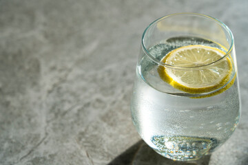 A glass of water with lemon on a concrete background with a place for your text. High quality photo