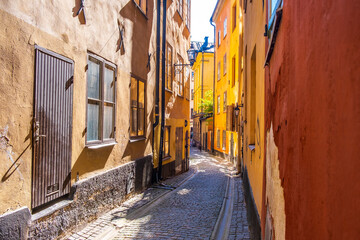 Colourful historic buildings and houses in Gamla Stan. Romantic medieval city centre alleys. Popular tourist destination in Scandinavia on a sunny day.