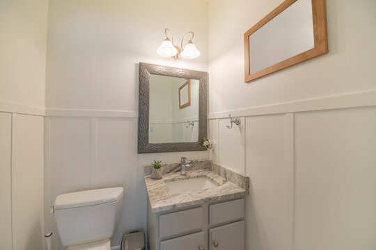 Interior of a white painted bathroom with vanity sink and mirror