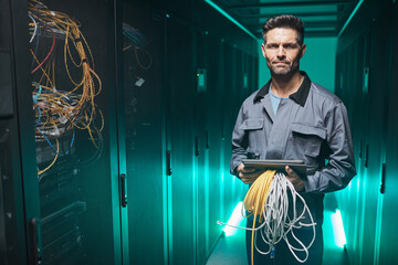 Waist up portrait of mature network engineer looking at camera and using digital tablet in server room during maintenance work in data center, copy space
