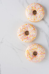 Donuts on white marble surface. Photo flat lay, top view.