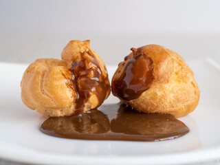Two cakes buns poured with chocolate