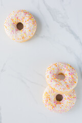 Donuts on white marble surface. Photo flat lay, top view.