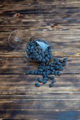 Honeysuckle in a glass glass on a wooden background is the first spring useful berries with...